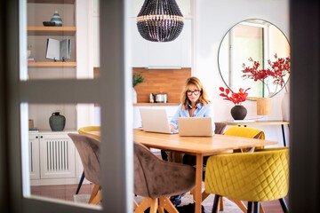 Attractive woman with earphones using laptops for work