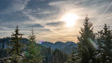 Tief stehende Sonne über den bayerischen Alpen im Winter (Deutschland)