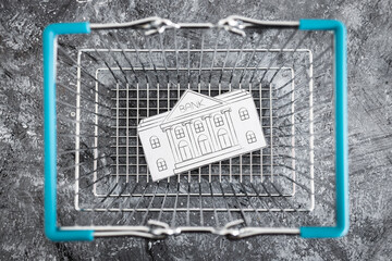 merging and holdings, bank made of paper inside of shopping basket ready to be bought by a...