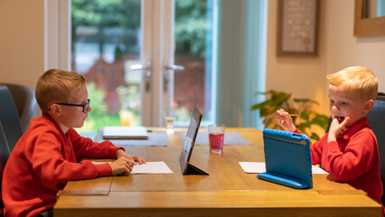 Boys working on homework on laptop