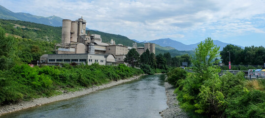 Fototapeta na wymiar Fabrik an Flusslauf in Italien