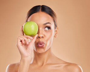 Beauty, skincare or woman with apple in studio on beige background for healthy nutrition or clean diet. Eye, hand or girl model advertising or marketing natural fruits for nutrition or wellness