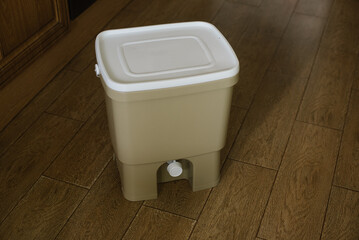 Trash bin for composting from kitchen at home on the floor. Copy space. Recycling organic scarps concept. Sustainable, ecology, zero waste lifestyle