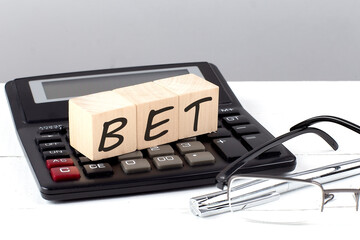 BET concept on wooden cubes on calculator on white background