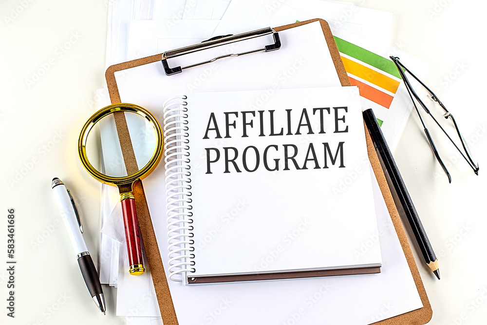 Poster affiliate program text on notebook with clipboard on white background