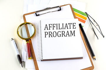 AFFILIATE PROGRAM text on notebook with clipboard on white background