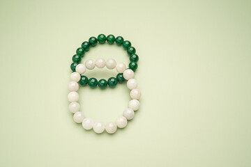 Top view of white and green jade rings on a green background