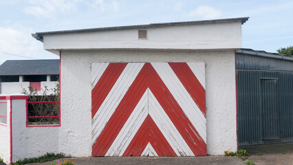 Líneas rojas y blancas en puerta de madera en garage de casa rural