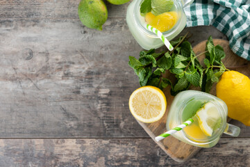 Lemonade drink in a jar glass and ingredients on wooden table. Top view. Copy space