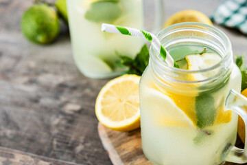 Lemonade drink in a jar glass and ingredients on wooden table. Copy space