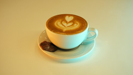 a glass of latte and a piece of chocolate
