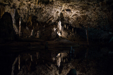reflection of the stalactites on a still surface of the underground lake in the Macocha cave