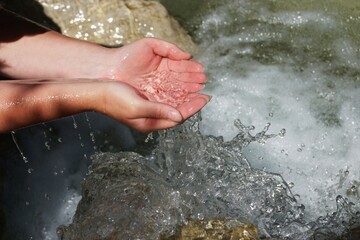 Beautiful woman hands in a river with drinking water quality