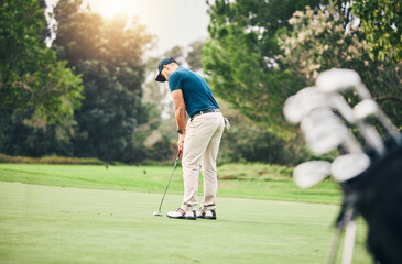 Man, golf ball and putter on grass to ready for game, sport and aim shot in competition with focus...