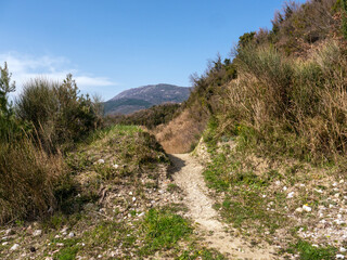 Fototapeta na wymiar Rocky mountain footpath over top of the hill under clear blue sky
