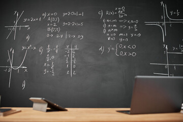 Horizontal image of workplace of teacher with gadgets and blackboard with new material on it