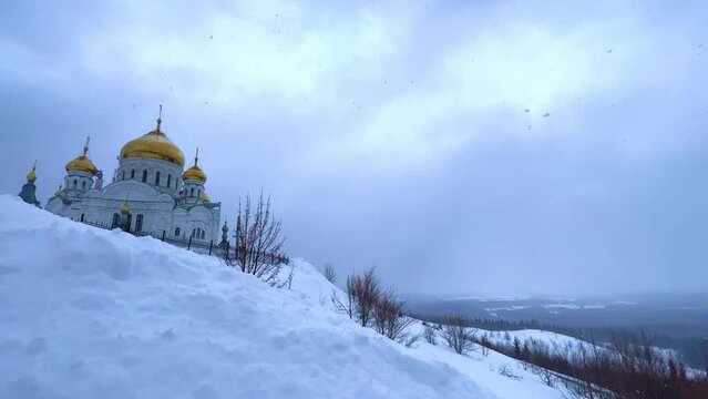 Belogorsky St. Nicholas Orthodox Missionary Monastery. Russia, Perm Krai, Belaya Gora. The temple on the hill in winter. Monastery on the background of snow. 4K