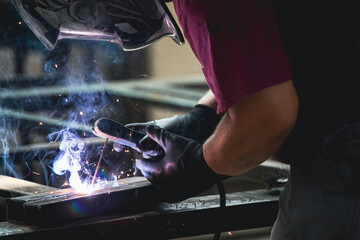 Industry worker welding iron pieces at work