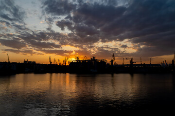 sunset in industrial landscape of commercial seaport. Sunset at seaport.