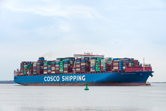 Stade, Germany – March 19, 2023: Container ship COSCO SHIPPING SCORPIO on Elbe river heading to Hamburg.