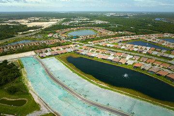 Obraz premium View from above of densely built residential houses under construction in closed living clubs in south Florida. American dream homes as example of real estate development in US suburbs