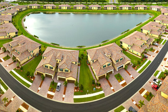 View from above of densely built residential houses near retention ponds in closed living clubs in south Florida. American dream homes as example of real estate development in US suburbs