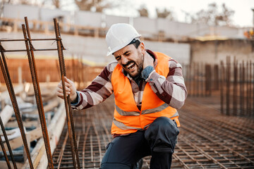 A site worker has injured his neck, so he is touching his painful place and screaming in pain.