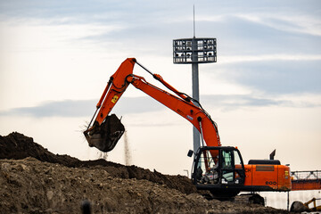 砂山を削る切削機、赤いショベルカー