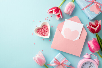 Mother's Day concept. Top view photo of pink open envelope with postcard tulips present boxes alarm clock and heart shaped saucer with sprinkles on isolated pastel blue background