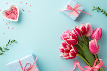 Mother's Day celebration concept. Top view photo of bunch of tulips gift boxes with bows and heart shaped saucer with sprinkles on isolated pastel blue background with empty space