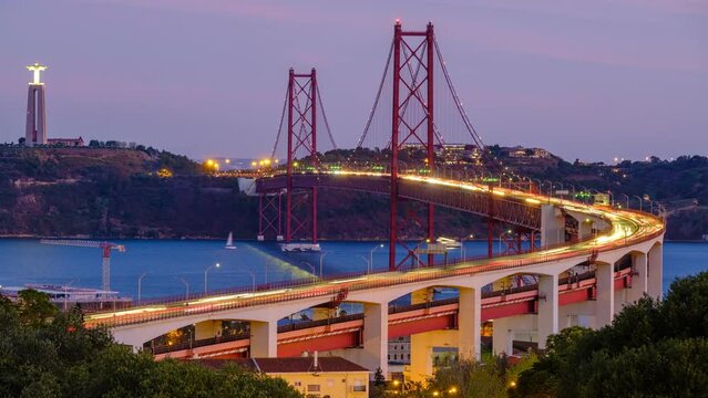 Time-lapse of Lisbon view from Miradouro do Bairro do Alvito tourist viewpoint of Tagus river, traffic on 25th of April Bridge and Christ the King statue in evening twilight. Lisbon, Portugal
