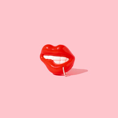 Beautiful sensual red lips with piercing ring on pink background.