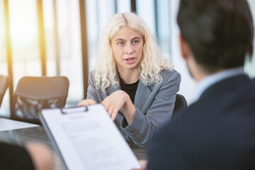 Young business woman focused eyes confident talk to your boss attentively in office meeting room...