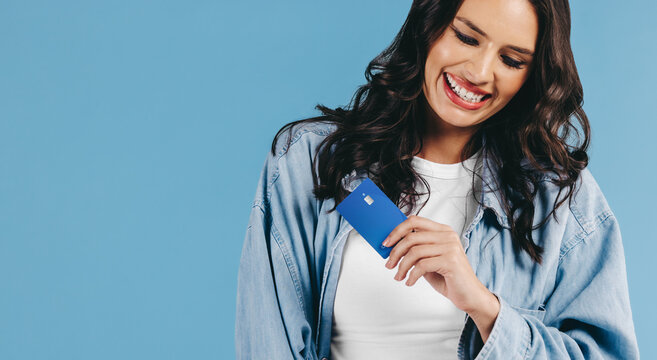 Gen Z woman embraces the rise of modern banking as she smiles with a credit card in her hand