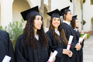 College graduates holding their university diplomas