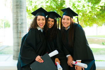 Happy women friends happy with their college diplomas