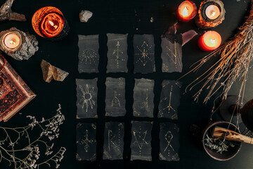 Black cards with magic signs laid out on a dark table. Halloween