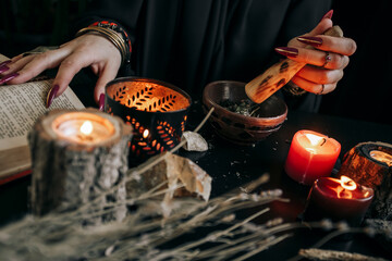 A woman grinds dried plants in a wooden mortar