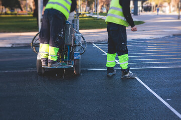 Process of making new road surface markings with a line striping machine, workers improve city...