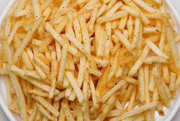 French fries background, closeup shot. Delicious potatoes with a golden fried crust. French fries background. Potato straw