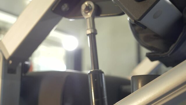 Slow motion shot of a gym machine hydraulics extending and retracting during use