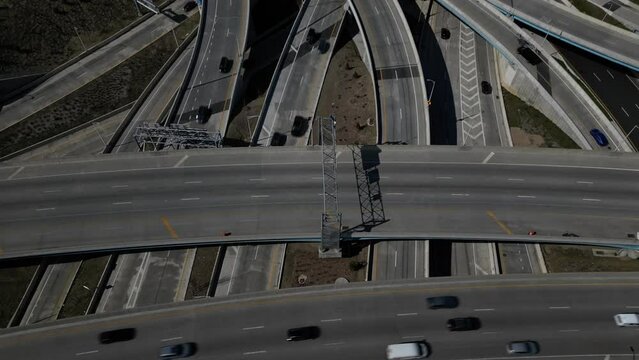 An aerial view high over a highway intersection in Queens, New York on a sunny day. The drone camera tilted downwards, dolly out then tilt up over the complicated interchange.
