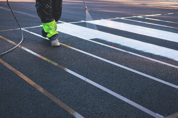 Process of making new road surface markings with a line striping machine, workers improve city...