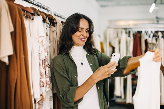 Social media marketing for small business: Shop owner taking a picture of a clothing item
