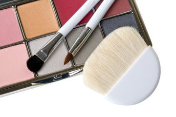 cosmetic brushes with  eye shadow dust sitting on top of palette