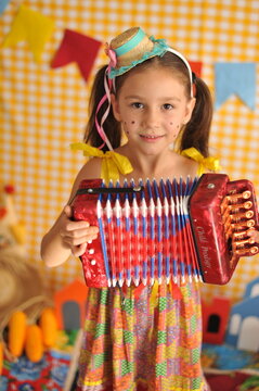menina com acordeon em festa feriado caipira, festa junina 
