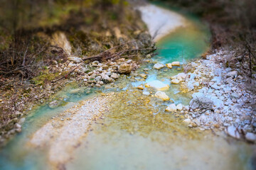 Mountain stream with turquoise water and stones in autumn forest