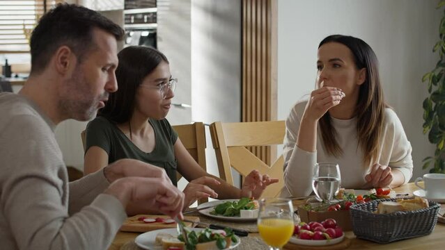 Caucasian family of three sharing breakfast food together. Shot with RED helium camera in 8K. 