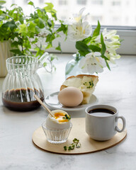 breakfast, soft-boiled egg, coffee on the background of the window
