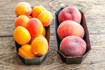 ripe fruits apricots and peaches in store packaging on a wooden surface